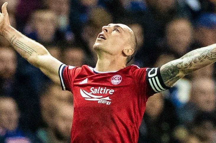 Watch Scott Brown celebrate in front of fuming Rangers fans after diving header for Aberdeen as missiles are thrown