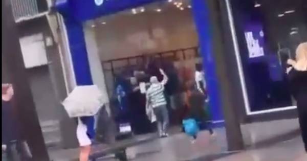 Celtic fan celebrates derby thrashing by singing outside Rangers shop in Belfast